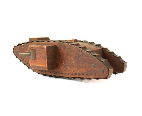 A wooden and metal trench art style model of a British First World War tank, with moveable side cannons, 24cm long and 7cm hi