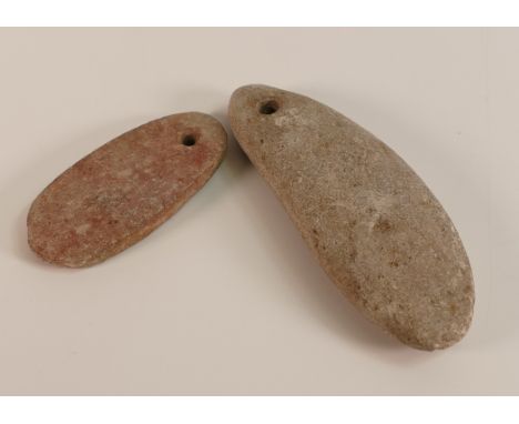 Two Stone Axe Heads with pierced holes for the attaching of twine. Length of longest: 10.2cm