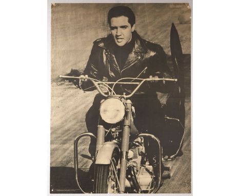 Original vintage photograph showing Elvis Presley in aleather jacket riding a Honda 305 Superhawk motorcycle with his guitar 