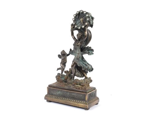 A bronzed cast metal figural mantel clock. With Venus holding aloft a shell shaped clock with gilt metal hands and enamelled 