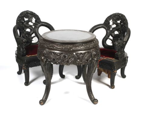 A 20th century Chinese carved hardwood drum table and two dragon throne chairs. The chairs with entwined pierced dragon backs