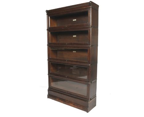 An early 20th century Globe Wernicke dark stained oak glazed five tier bookcase. Bearing ivorine labels, each tier with hinge