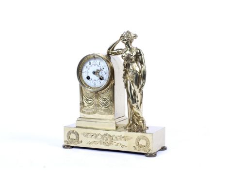 An early 20th century brass mantel clock. The enamel dial with Arabic numerals and painted with flowers, placed in a shaped c