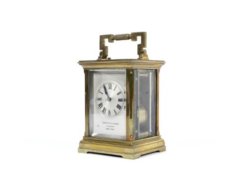 A Hamilton &amp; Inches (Edinburgh and Paris Made) brass carriage clock. With silver dial and black Roman numerals, with beve