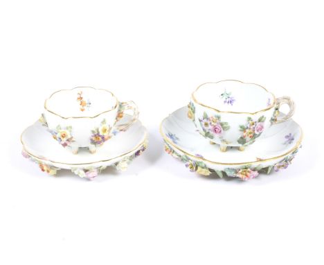 Two late 19th century Meissen flower encrusted teacups and saucers. The larger example outside decorated, with blue crossed s