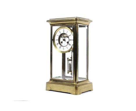 A brass and bevelled glass mantel clock, circa 1900. With dual mercury pendulum, white enamelled dial and chapter ring with b