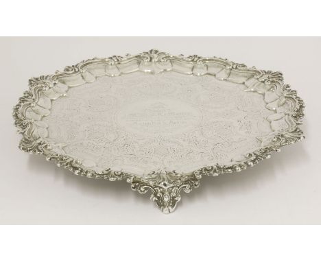 A Victorian silver salver,by George Henry James, London 1886,of shaped circular form with leafy scroll and shell border on th