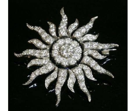An 18ct gold diamond set sunburst brooch,with a brilliant cut diamond, claw set to the centre.  A surround of smaller brillia