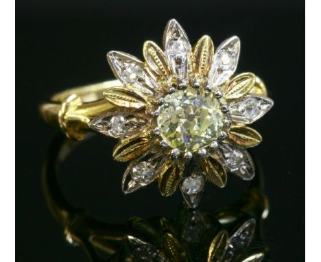 A two-colour gold, diamond set, flower head cluster ring,with an old European cut diamond, possibly fancy light yellow, claw 