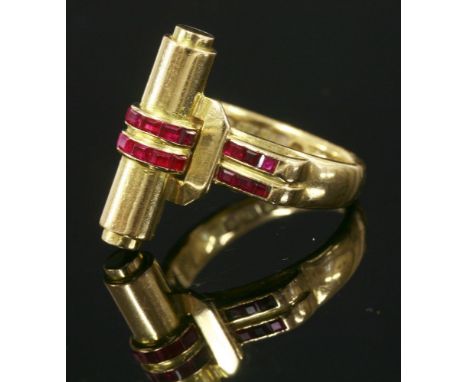 A ruby ring,with a circular baton head, with two rows of calibré, square rubies, channel set to the centre and one shoulder, 