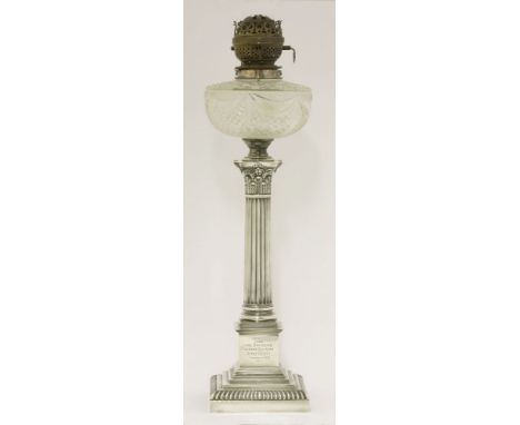 A silver oil lamp,by Goldsmiths' & Silversmiths' Ltd., London 1910,the Corinthian column on stepped in square base with gadro