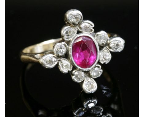 A synthetic ruby and diamond lozenge-shaped cluster ring,with an oval French cut synthetic ruby, rub set to the centre.  A bo