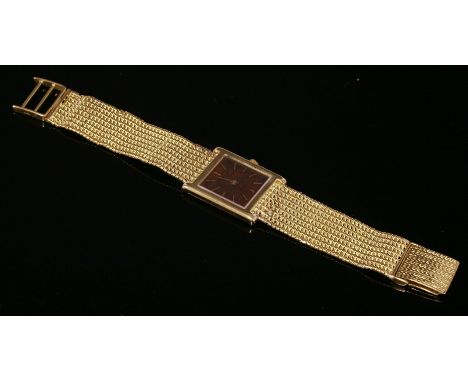 A gentlemen's 18ct gold Piaget mechanical bracelet watch,with a tank-style case.  A wood dial with gold batons and hands to a