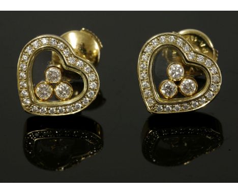 A pair of Chopard 'Happy Diamonds' heart-shaped gold earrings,with a glazed heart-shaped centre.  Three 'Happy Diamonds' to a