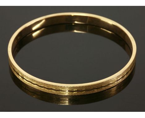 An Art Deco 15ct gold hollow slave bangle,with engine turned fish scale and wriggle decoration, London 1926.Interior diameter