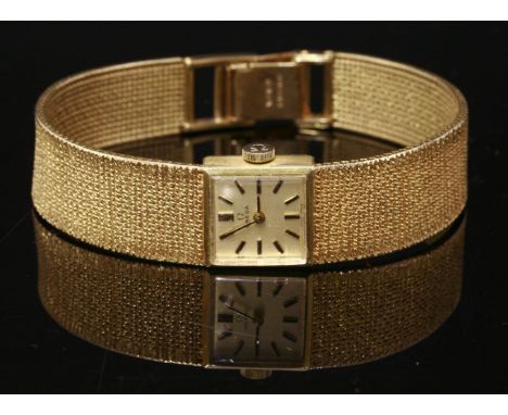 A ladies' 9ct gold Omega mechanical bracelet watch, c.1970,a square champagne dial, raised black and gilt batons and hands, t