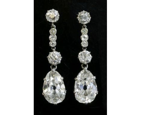 A pair of diamond drop earrings,composed of an old European cut diamond, claw set in a rex collet at the top.  An articulated