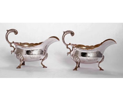 A pair of George III silver sauce boats,possibly by William Sanden, London 1763,of usual form with wavy rims and leaf capped 