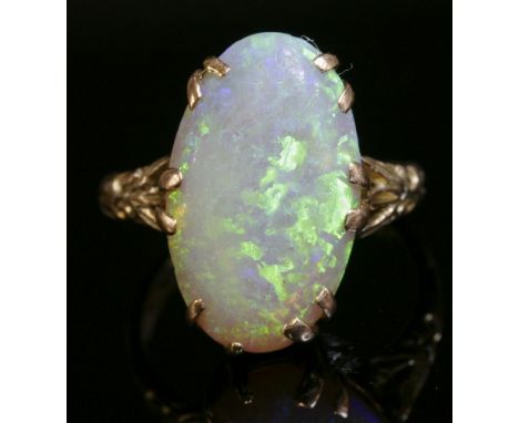 An Edwardian single stone opal ring,with a semi-black, oval, cabochon opal, double claw set to a plain collet.  Trifurcated s