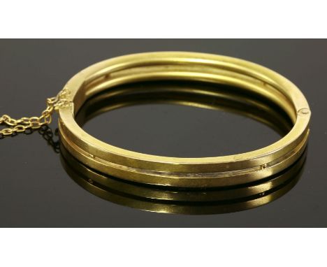 An Edwardian, two-row, gold-hinged bangle,with two hollow flat sections with bead spacers.  Concealed box clasp and safety ch