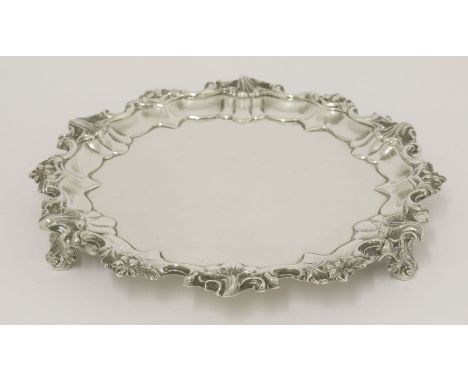 An Edwardian silver salver,by Messrs Barnards, London 1901,of shaped circular form on three foliate bracket supports with fol