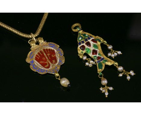 An Indian high carat gold and enamel Vishnupada pendant,depicting the footprints of Vishnu in red to a white ground with a bl