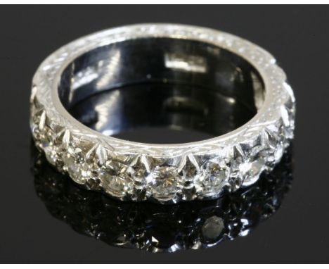 A white gold diamond set half eternity ring,with nine brilliant cut diamonds, all claw set to a flat section band.  Hand engr