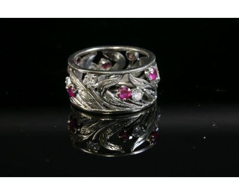 A synthetic ruby and diamond floral band ring, with brilliant cut diamonds and circular synthetic rubies, four claw set to pl