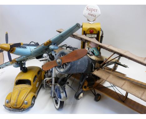 Five large scale tin plate model aeroplanes, cars and motorbikes with a matching petrol pump