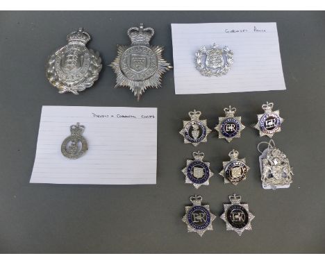 A collection of various police badges including Cornwall, Devon and Exeter helmet plate, Guernsey Police, Dorset and Bournemo