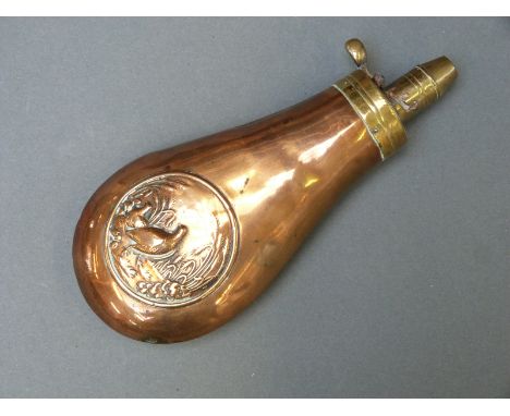 A copper and brass powder flask with embossed decoration of partridge in a corn field, 18cm long.  