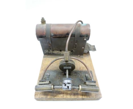 A stationary live steam engine with twin opposed oscillating cylinders, mounted on a wooden base