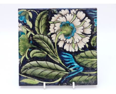 William de Morgan tile with floral decoration on a dark blue ground, maker's mark to back (15.5cm square)