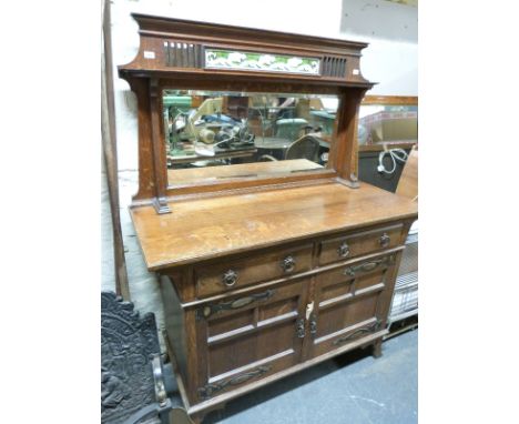 An oak Arts and Crafts style dresser with tile insert, bevelled glass mirror, pierced frieze and Art Nouveau copper fittings 