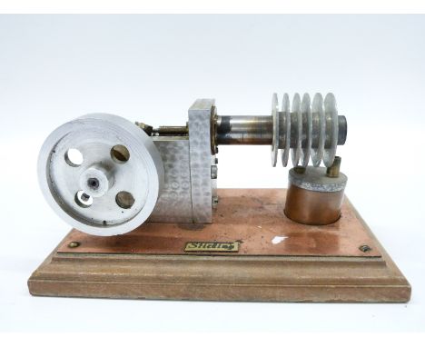 A freelance sterling hot air engine mounted on a wooden base with spirits burner
