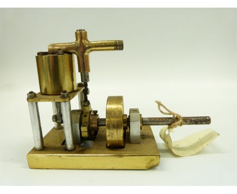 A model marine live steam engine, the single acting cylinder with solid brass flywheel, mounted on brass base 