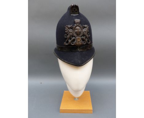 A vintage City of London police helmet with D66 helmet badge
