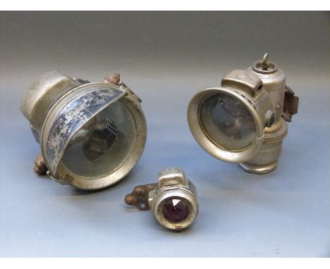 A Lucas Calica carbide lamp and Powell and Hamner motorcycle front and rear light