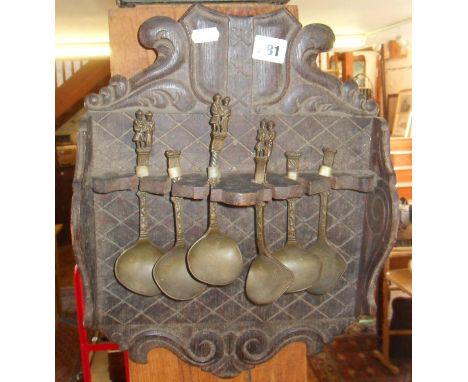 Antique Dutch brass 'Apostle' spoons mounted on carved wood shelf (A/F)