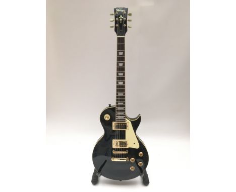 A Vintage Les Paul style electric guitar in black. Comes supplied with a hard carry case.