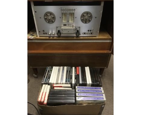 A vintage Pioneer RT707 reel to reel machine together with a box of reels and a microphone. The player is housed in a wooden 