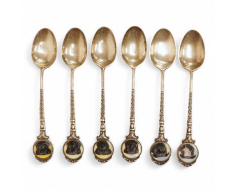 A matched set of six mainly George V silver/white metal and enamel teaspoons, with terminals decorated with dog's heads, 13.6