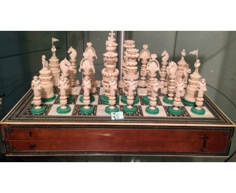 A fine 19th Century Indian Ivory chess set, the one side left natural, the other side left natural with stained green bases. 