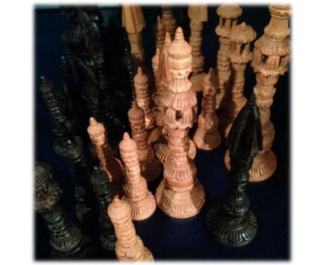 A black and light brown wooden Indian chess set.