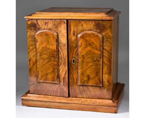 An Early 19th Century Walnut Miniature Cabinet, with moulded edge to top, fitted three small drawers enclosed by a pair of fi