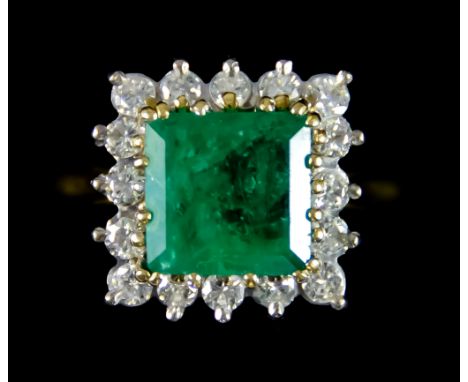 An Emerald and Diamond Ring, set with a centre emerald, approximately 3ct, surrounded by small brilliant cut white diamonds, 