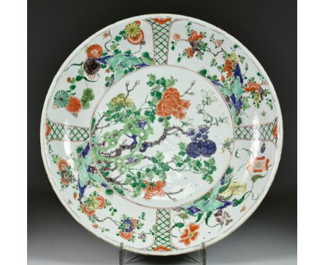 A Chinese Kangxi Famille Verte Porcelain Charger, enamelled with rockwork and flowering branches, the rim with similarly deco