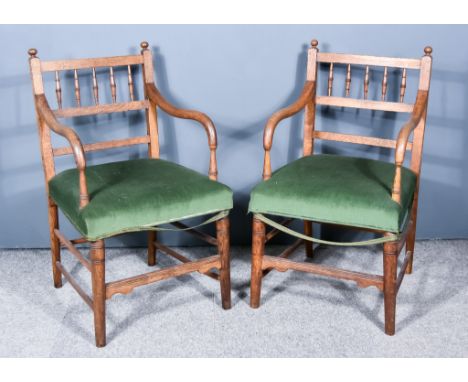 A Pair of Early 20th Century Oak Armchairs, with spindle turned backs, seats upholstered in green dralon and on turned front 