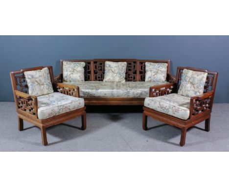 A Chinese Hardwood Three Piece Lounge Suite, the low backs and arms inset with fretted scroll panels, and on square legs, com