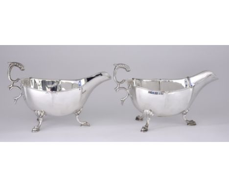 A Pair of Chinese Silver Oval Sauce Boats, stamped Sterling Wai Kee, with shaped rims, panelled bodies, leaf capped double sc